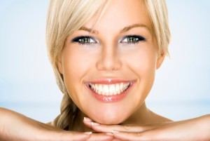A young blond woman smiling and showing off her white teeth