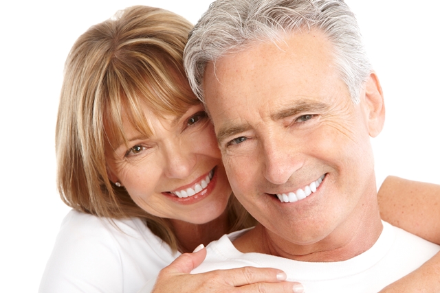 An elderly couple hugging and smiling for the camera