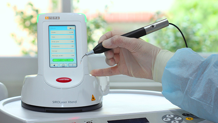 A dentist's hand holding a piece of dental technology