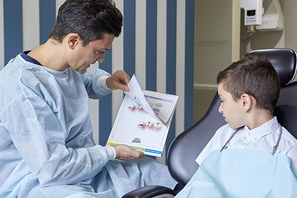 A KB Village dentist explaining teeth to a young patient