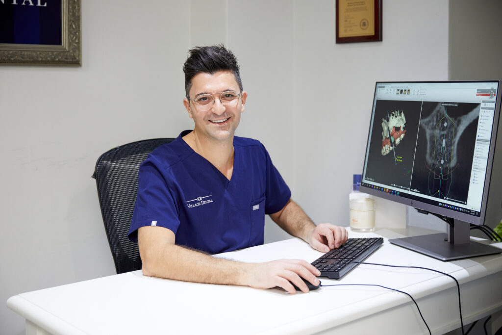 professional dentist smiling by computer