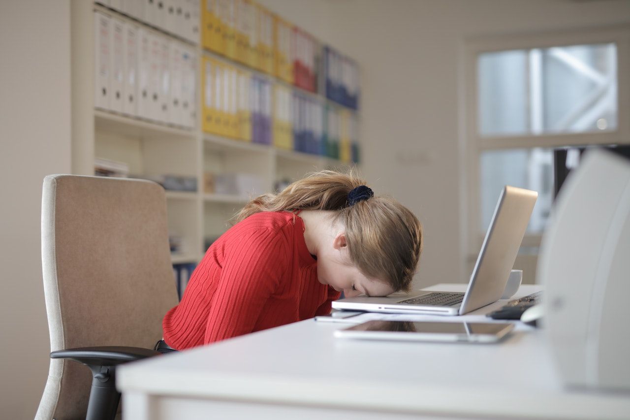 Tired woman sleeping on her laptop