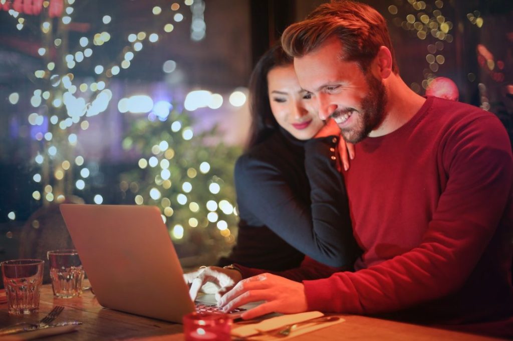 A happy couple smiling at their computer