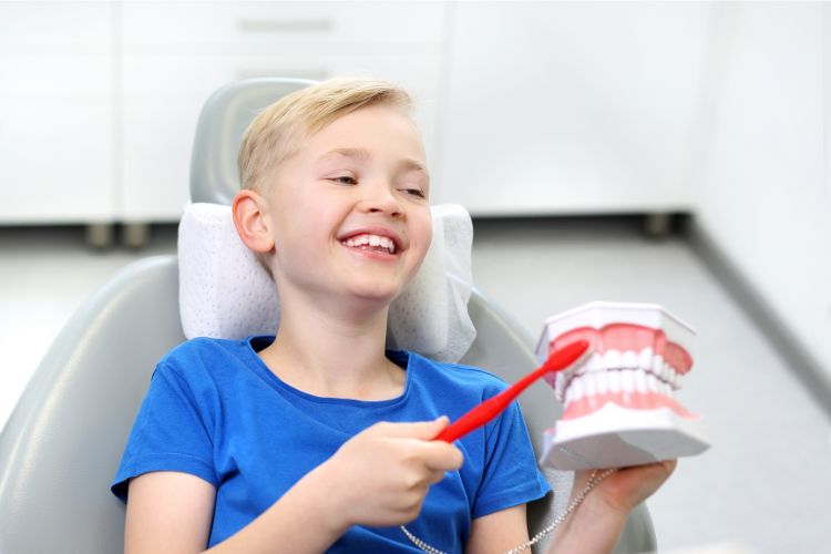 Boy in a dental chair holding a toothbrush